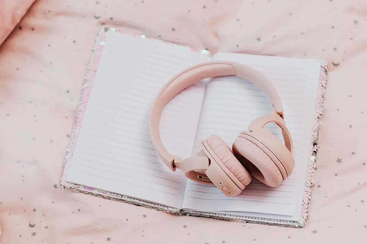 Pink headphones resting on an open notebook