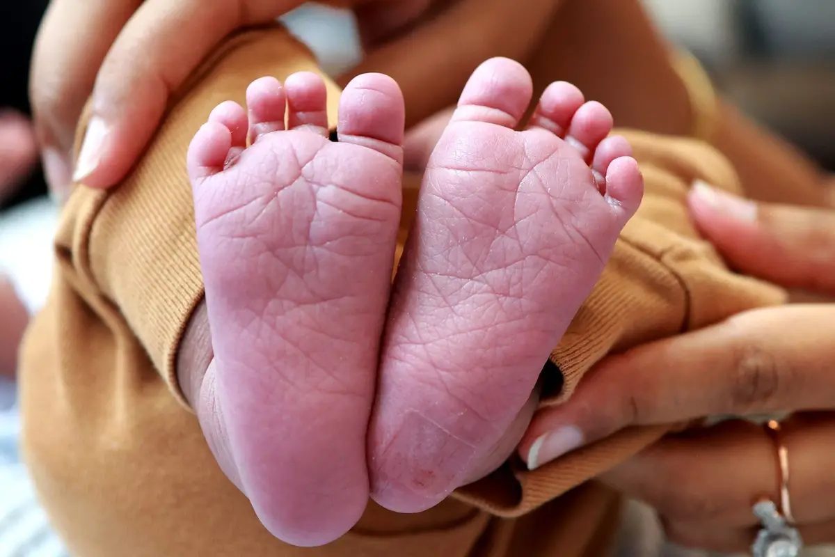 A parent's hands holding a newborn's feet