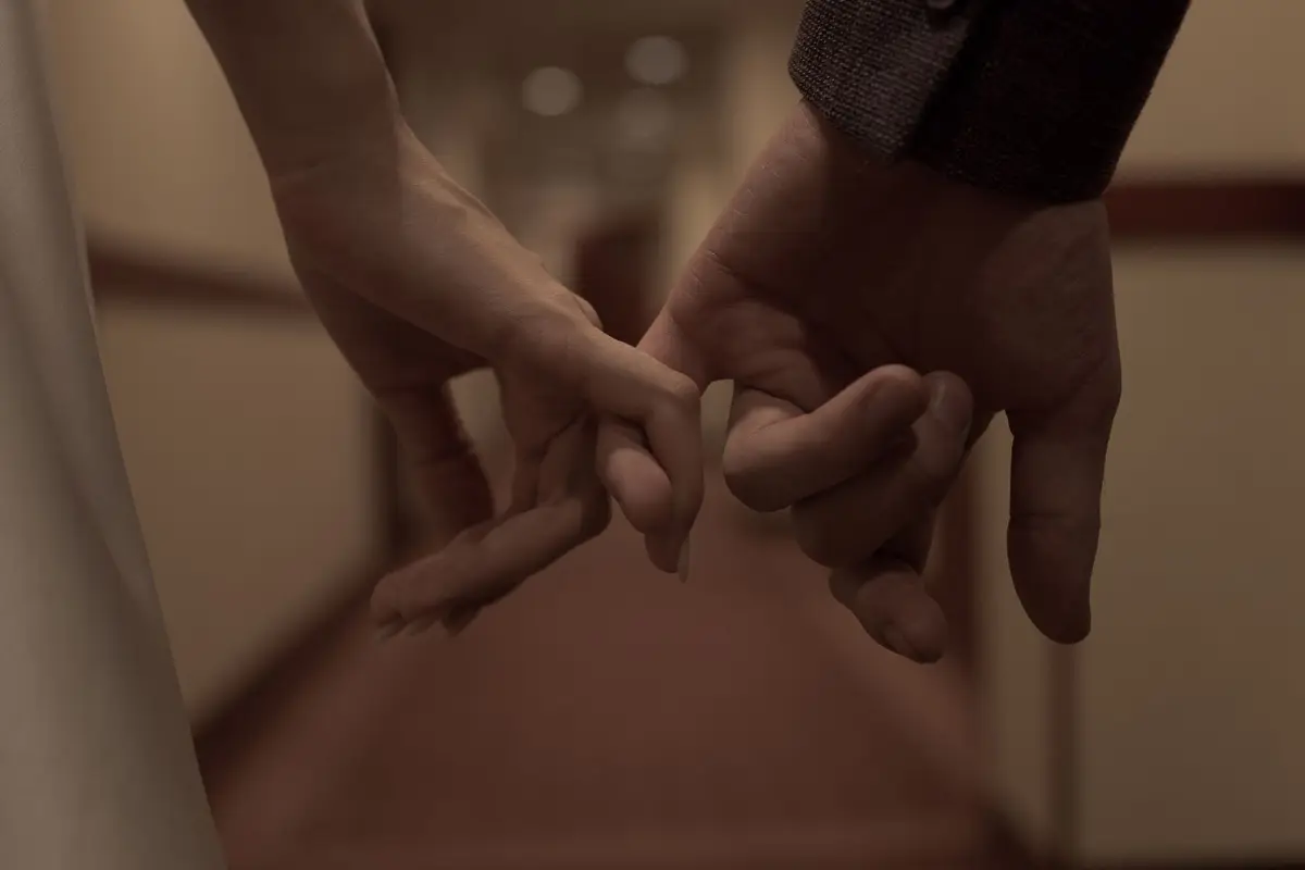 Two people linking little fingers in a pinky promise
