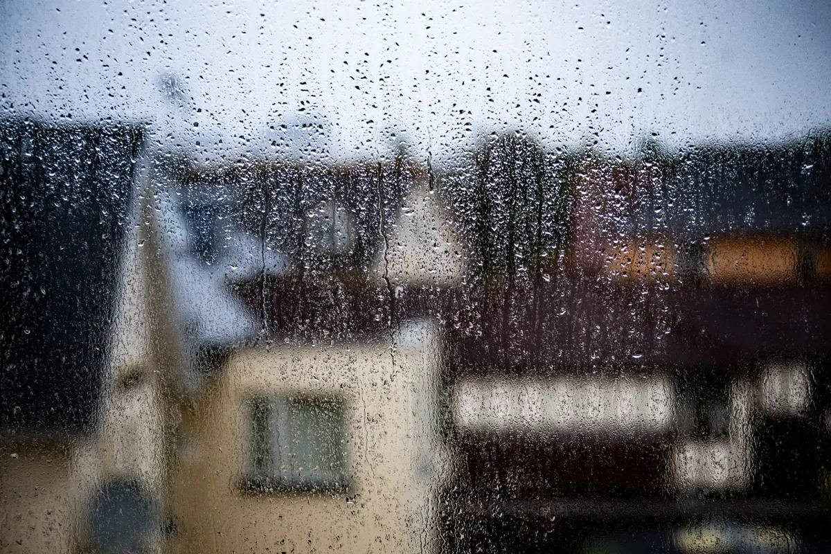 Rain on a window looking out over rooftops