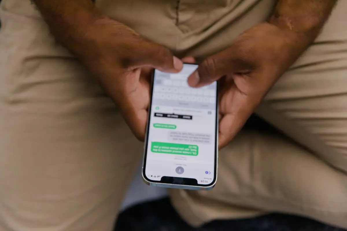 Hands holding a phone with a message thread open