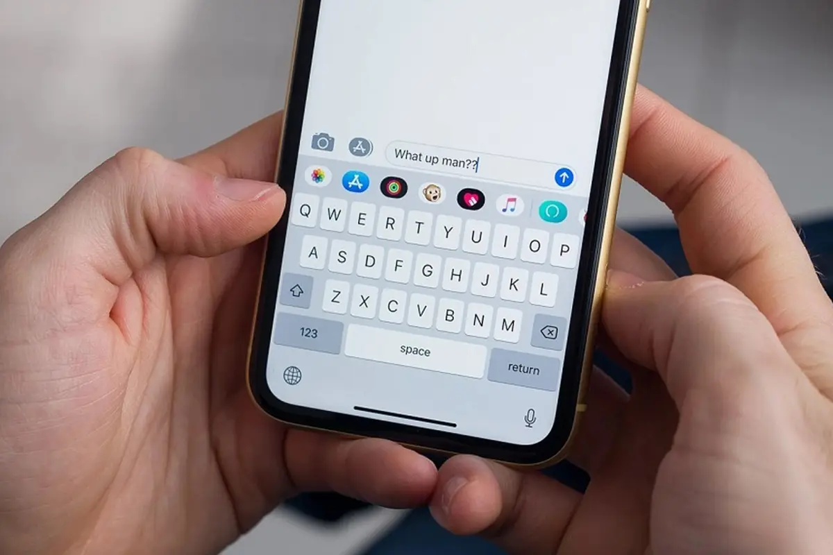 Two hands typing a message on a phone